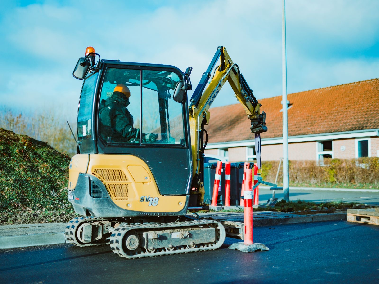A mini-excavator preparing a pervious sub-base on site before resin is laid